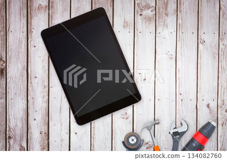 Tools and tablet on wooden background Tools and tablet on wooden background 134082760