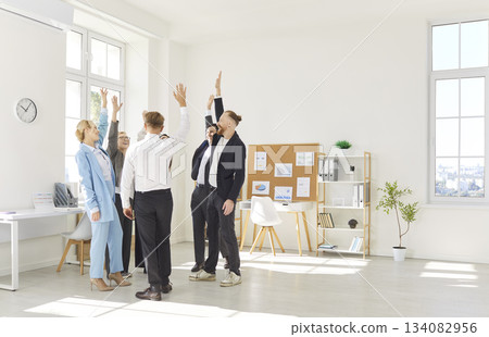 Professional Business Team Celebrating Success With Raised Hands In Office Professional Business Team Celebrating Success With Raised Hands In Office 134082956