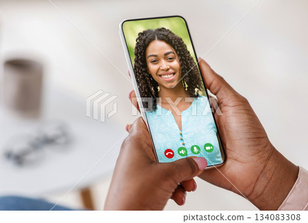 Pov of black person holding cell phone in hand video calling online and talking with woman looking on mobile screen using smartphone videochat app, staying at home, closeup view, selective focus Pov of black person holding cell phone in hand video calling online and talking with woman looking on mobile screen using smartphone videochat app, staying at home, closeup view, selective focus 134083308