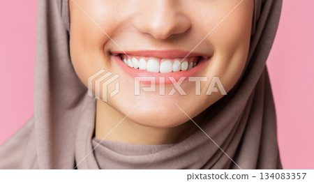 Dental care and stomatology concept. Closeup of wide white smile of muslim girl in hijab, young islamic woman happy after teeth alignment procedure Dental care and stomatology concept. Closeup of wide white smile of muslim girl in hijab, young islamic woman happy after teeth alignment procedure 134083357