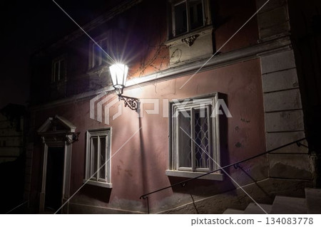 Flat design showing nighttime alley lighting pink wall lamp casting starburst glow on vine remnants 134083778