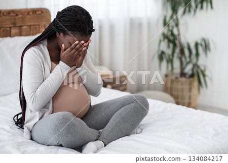 Sad Black Pregnant Woman Crying At Home, Having Maternity Depression, Suffering Hormonal Changes During Pregnancy, Desperate Lady Sitting On Bed In White Bedroom Covering Face With Hands, Copy Space Sad Black Pregnant Woman Crying At Home, Having Maternity Depression, Suffering Hormonal Changes During Pregnancy, Desperate Lady Sitting On Bed In White Bedroom Covering Face With Hands, Copy Space 134084217
