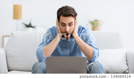Shocked Businessman At Laptop Computer Touching Head Having Problem Working Online Sitting On Couch At Home. Distance Work Issue And Internet Connection Problems Shocked Businessman At Laptop Computer Touching Head Having Problem Working Online Sitting On Couch At Home. Distance Work Issue And Internet Connection Problems 134084524