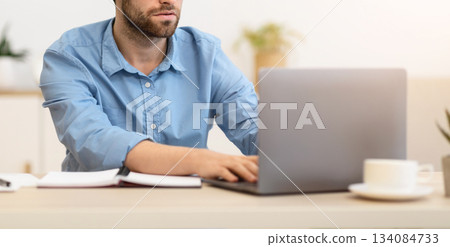 Focused Businessman Frowning Working On Laptop Having Difficult Task At Workplace In Modern Office. Serious Entrepreneur Typing On Computer Indoors, Having Issue With Internet Connection 134084733