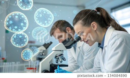 Focused male and female scientist team in laboratory conducting medical research on virus with microscope, showing happy concentration 134084890