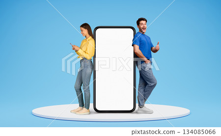 Shopping mobile app, black friday offer, season sale. Happy european man and woman standing on platform by big phone with white blank screen, using smartphone and showing thumb up, blue background Shopping mobile app, black friday offer, season sale. Happy european man and woman standing on platform by big phone with white blank screen, using smartphone and showing thumb up, blue background 134085066
