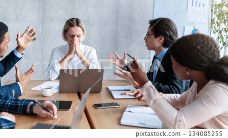 Aggressive Colleagues Shouting At Unhappy Victimized Business Lady Sitting At Desk In Modern Office. Problems And Disagreement At Work, Business Team Communication, Corporate Bullying Issue. Panorama 134085255