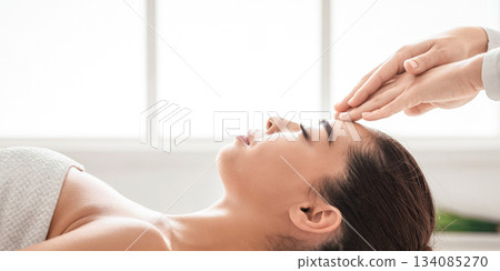 Beautiful asian woman in spa salon enjoying acupressure head massage, getting wellness treatment with professional masseur, relaxed female lying on table with closed eyes, side view with copy space Beautiful asian woman in spa salon enjoying acupressure head massage, getting wellness treatment with professional masseur, relaxed female lying on table with closed eyes, side view with copy space 134085270