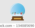A winter scene inside a snow globe with a smiling snowman stands on snowy hills and a small red house with a chimney adds warmth to the wintry landscape surrounded by evergreen trees. 134085690
