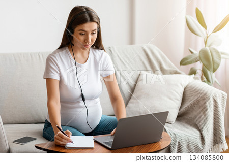 Online Courses For Future Moms. Pregnant Lady In Headset Study With Laptop At Home, Expectant Woman Taking Notes During Online Lesson, Enjoying Distance Learning And Remote Education, Free Space Online Courses For Future Moms. Pregnant Lady In Headset Study With Laptop At Home, Expectant Woman Taking Notes During Online Lesson, Enjoying Distance Learning And Remote Education, Free Space 134085800