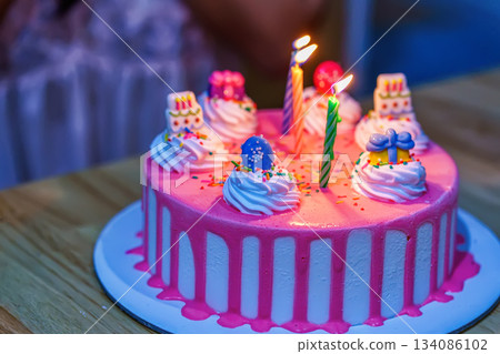 Pink birthday cake with candles Pink birthday cake with candles 134086102