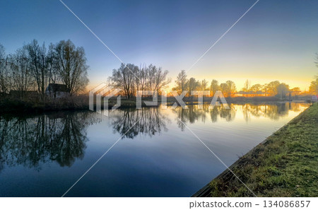 A Serene Sunrise Seen Rising Over a Tranquil River Landscape that is Captivating and Beautiful 134086857