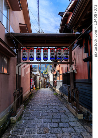 郡上八幡一條石板鋪就的小巷，兩旁是木質房屋，頭頂懸掛著燈籠。 134087072