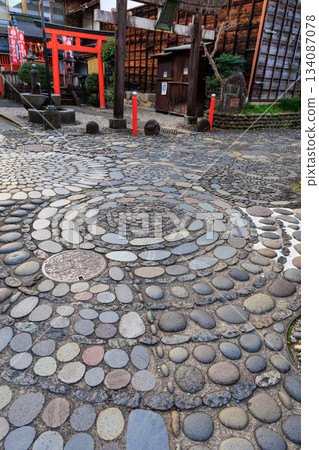 郡上八幡神社前的庭院裡，鋪著美麗的螺旋紋鵝卵石路面，紅色的鳥居鱗次櫛比。 134087078