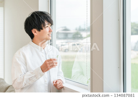 A man who wakes up in the morning and drinks water, hot water, and carbonated water (mineral water, water server) 134087081