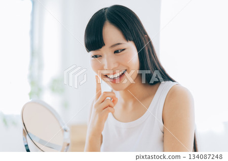 一位對更緊緻的肌膚感到滿意的女性 134087248