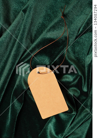 Blank tag on luxurious green velvet texture offering space for messaging 134087294