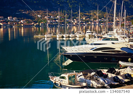 Marina with Luxury Yachts and Sailboats Against the Backdrop of Mountains in a Sunny Mediterranean Town 134087540