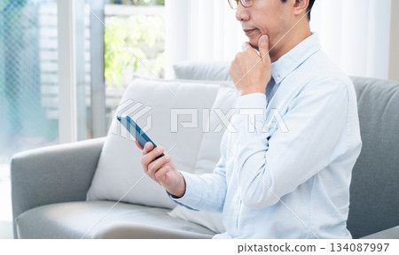 Mature man using a smartphone 134087997