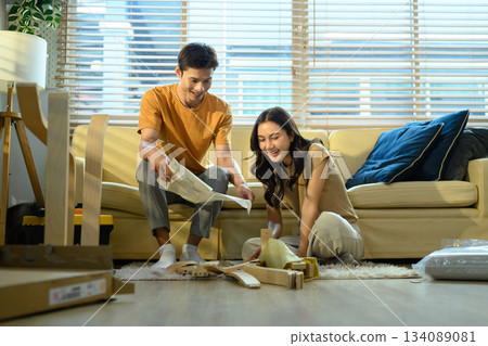 Happy couple reading introduction assembly a new furniture at home 134089081