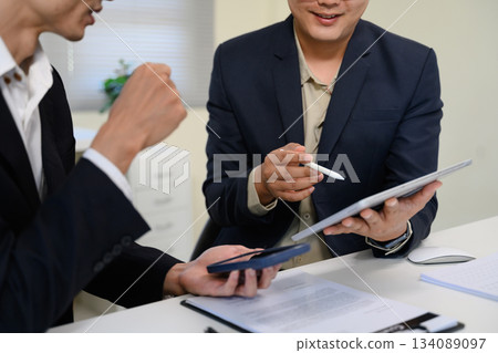 Asian business adviser meeting to analyze and discuss the situation on the financial report 134089097