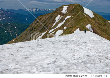 Climbers walking along the snowy valley of Mt. Ichinokura in the Tanigawa Mountain Range, with views of Mt. Mokura and Mt. Naeba Climbers walking along the snowy valley of Mt. Ichinokura in the Tanigawa Mountain Range, with views of Mt. Mokura and Mt. Naeba 134089181