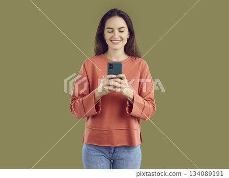 Smiling brunette young woman taking photo on smartphone Smiling brunette young woman taking photo on smartphone 134089191