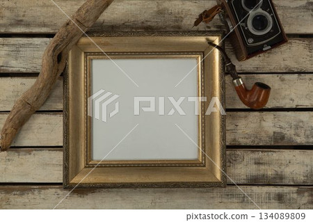 Photo frame and smoking pipe on wooden table 134089809