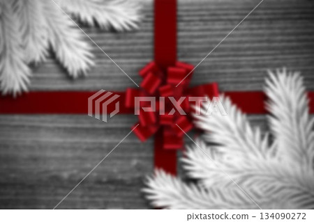 Flat-lay design is featuring red satin ribbon crossing grey wood planks with white conifer branches 134090272