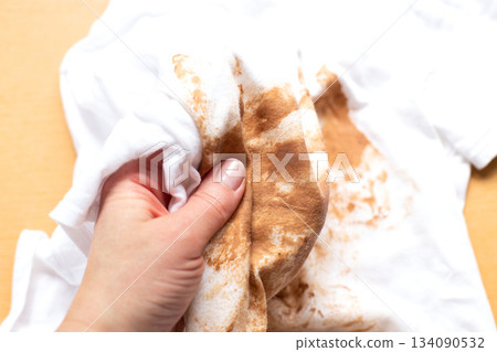 Woman showing large foundation stain on white t-shirt Woman showing large foundation stain on white t-shirt 134090532