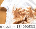 Dirty stains covering white t-shirt lying on wooden table 134090533