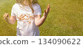 Girl child staining her white t-shirt with stain while enjoying a delicious chocolate bar in garden 134090622