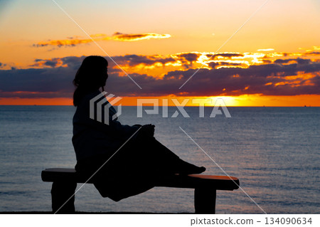 一位女士觀賞日落的剪影 一位女士觀賞日落的剪影 134090634