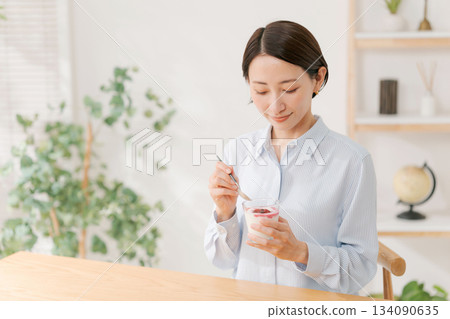 A woman in her 30s eating dessert 134090635