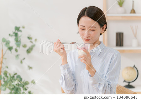 A woman in her 30s eating dessert 134090643