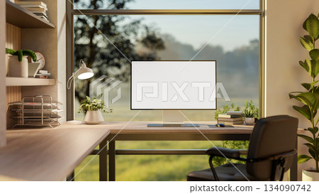 Blank screen computer on wooden table and armchair in glass wall room with green nature view outside Blank screen computer on wooden table and armchair in glass wall room with green nature view outside 134090742