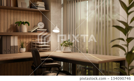 Wooden table with a lamp and armchair near a curtain covered glass window with nature view outside. Wooden table with a lamp and armchair near a curtain covered glass window with nature view outside. 134090746