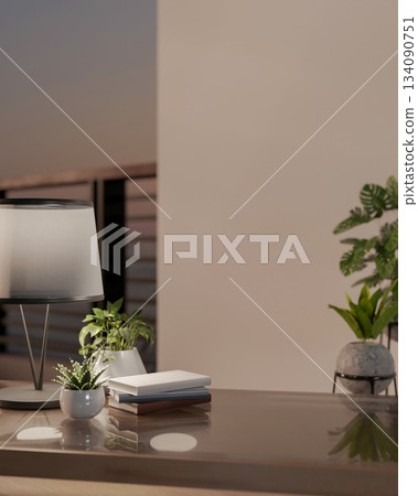 Close up of a glass top wooden table with a lamp, books and potted plants in a room with balcony. Close up of a glass top wooden table with a lamp, books and potted plants in a room with balcony. 134090751