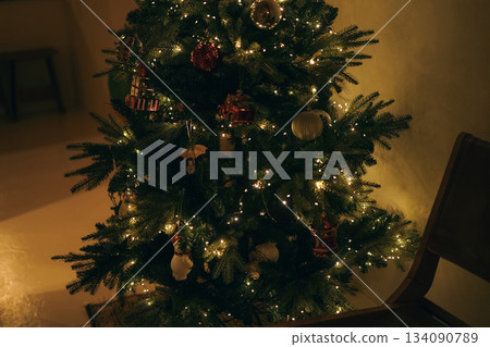 a cozy interior space with wooden chairs and Christmas trees a cozy interior space with wooden chairs and Christmas trees 134090789