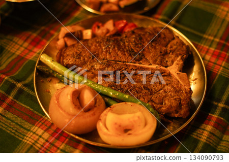 Large TBone Steak and Vegetables on a Christmas Themed Plaid Tablecloth Large TBone Steak and Vegetables on a Christmas Themed Plaid Tablecloth 134090793