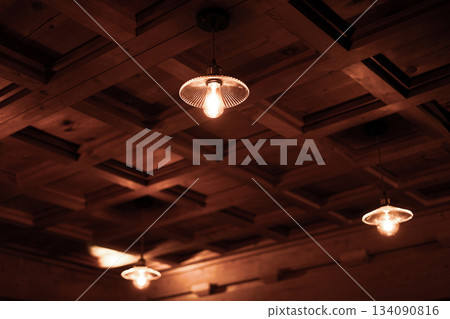 Retro Glass Lampshades and Warm Orange Light Interior Lighting Hanging from a Wooden Lattice Ceiling 134090816