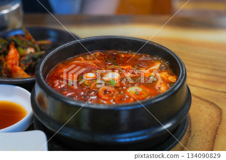 Spicy Soft Tofu Stew (Sundubu Jjigae) Simmering Hot in a Korean Earthenware Pot Spicy Soft Tofu Stew (Sundubu Jjigae) Simmering Hot in a Korean Earthenware Pot 134090829