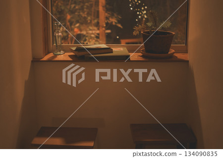 Books, small pots, and vintage vials on the windowsill of the night 134090835