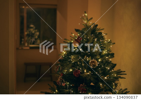 Warmly Lit Christmas Tree Decorations in a Cozy Winter Interior 134090837