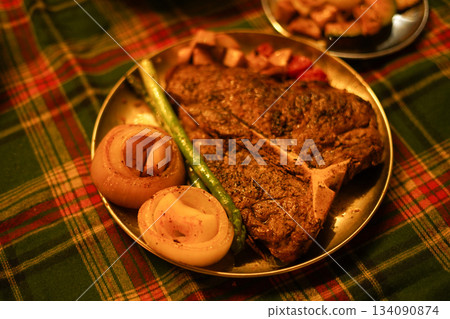 Large TBone Steak and Vegetables on a Christmas Themed Plaid Tablecloth Large TBone Steak and Vegetables on a Christmas Themed Plaid Tablecloth 134090874