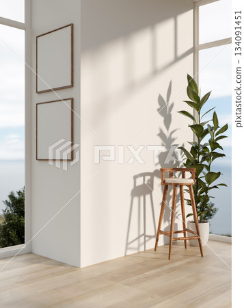 Empty frames on white wall with a chair and potted plant in a wooden floor room with scenery outside 134091451