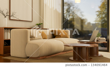 Laptop on wooden round table near a white sofa with cushion on brown carpet in lounge or living room 134091464