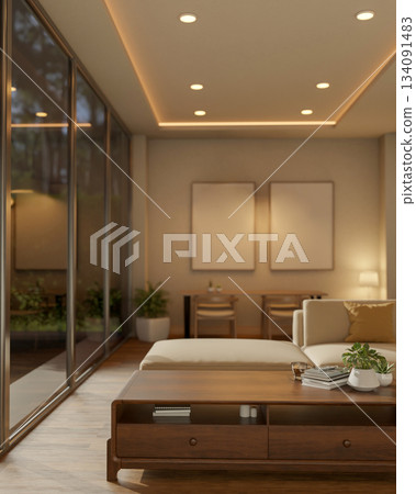 Coffee and books on glass top wooden table next to a white sofa with blank frames hanging on wall. Coffee and books on glass top wooden table next to a white sofa with blank frames hanging on wall. 134091483