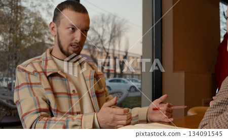 Mentor explaining key lesson points with a hand gesture to the colleague 134091545