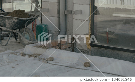Construction workers operating machinery and mixing materials on the site Construction workers operating machinery and mixing materials on the site 134091546